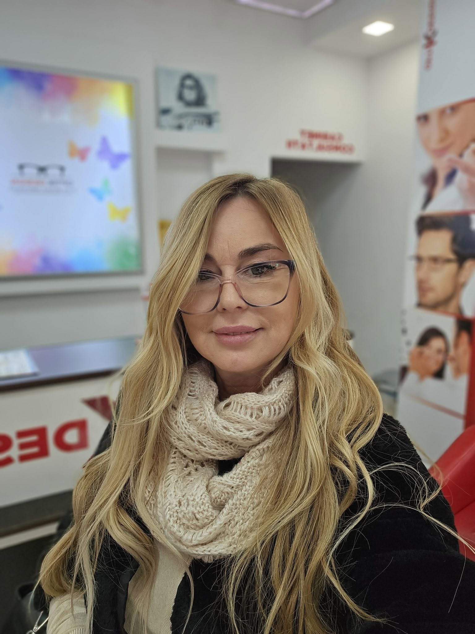 Clientă probând ochelari – OptiK Design Galați Clientă probând ochelari în cadrul OptiK Design, optică din Galați.