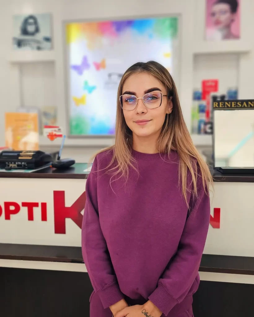 Clientă OptiK Design Galați Clientă OptiK Design purtând o pereche de ochelari în magazinul de optică din Galați.